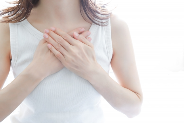 女性が胸をおさえて胸のサイズについて考えている画像