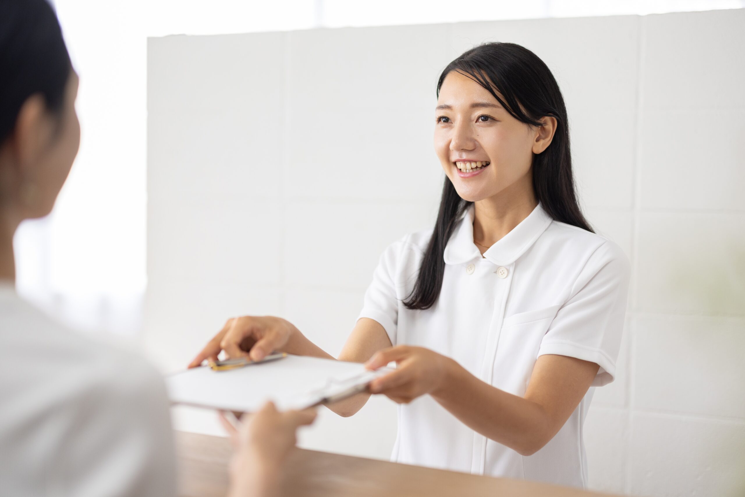 クリニックで受付をする女性